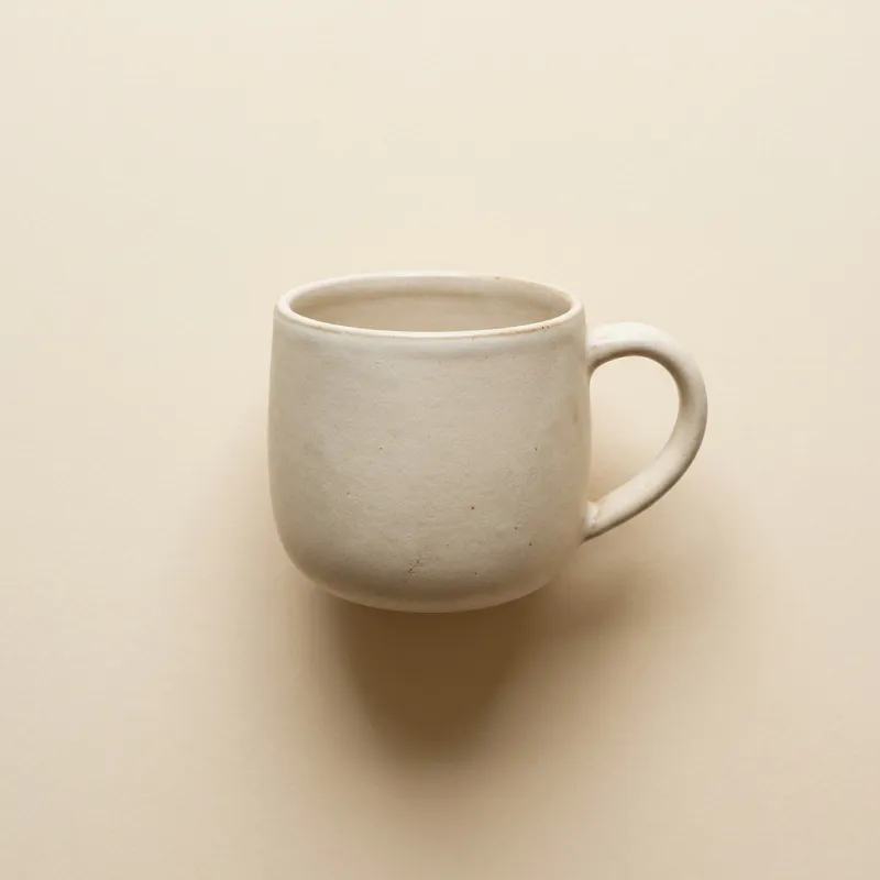Single matte ceramic mug on cream background — first-pass product hero generated by AnyCap.